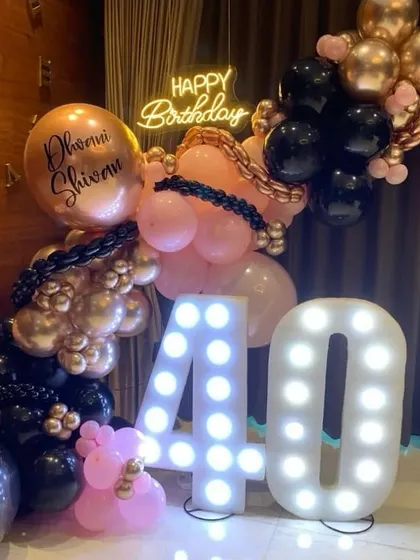 A chic and trendy 40th birthday celebration. We used a striking pink and black color scheme with rose gold accents, a custom personalized balloon, and large light-up "40" numbers to create a fun and glamorous party atmosphere.