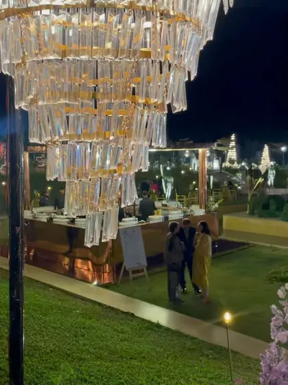 A stunning crystal chandelier hangs over the custom copper bar, adding a touch of glamour to the outdoor reception. This combination of rustic warmth and refined elegance is a signature of our design philosophy.
