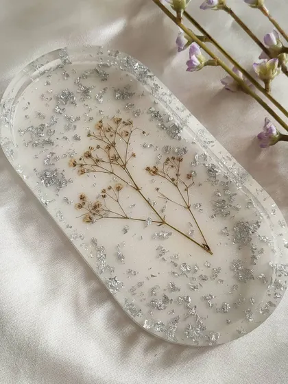 A closer look at the oval trinket tray, featuring preserved baby's breath and silver flakes. The design is delicate and adds a touch of nature to your decor.