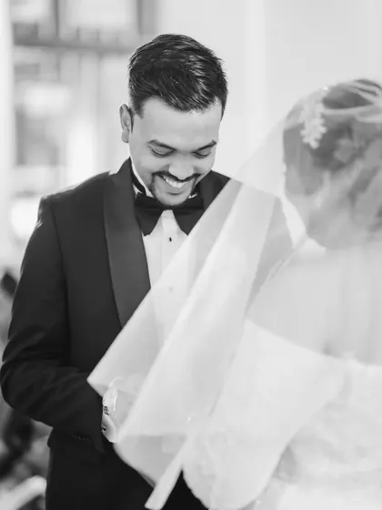 A candid black and white shot of the groom's happy reaction during the ring ceremony. Capturing the groom's emotions is just as important as the bride's.