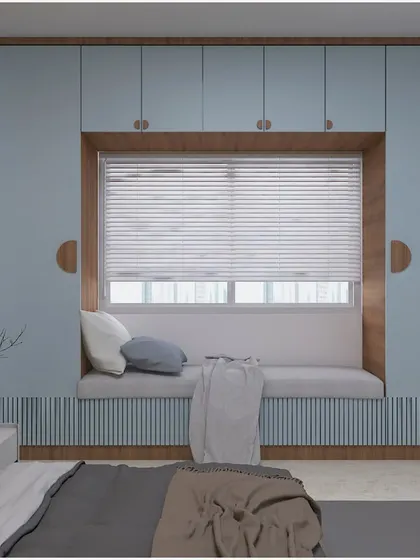 This innovative bedroom design features a wardrobe built around a window, creating a cozy bay window seat with storage underneath. The pastel blue color adds a calming touch.