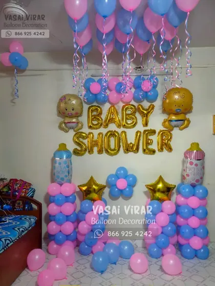 This is another example of a simple yet festive baby shower decoration for a home setting. It uses pink and blue balloon pillars, "BABY SHOWER" foil letters, and baby-shaped foil balloons to create a cheerful photo corner.