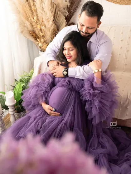 A quiet moment of connection for the parents-to-be. The soft purple gown and gentle embrace make this a romantic and beautiful maternity photograph.