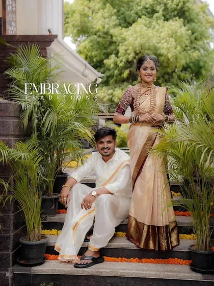 A classic portrait of the couple on the steps, framed by lush greenery. The text "Embracing Traditions" perfectly describes the feel of this shot.