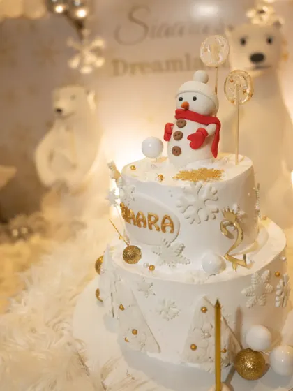 The adorable snowman-topped birthday cake for Siaara's winter dreamland party, complete with delicate snowflakes and golden details.