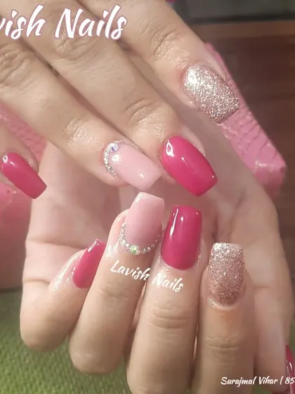 A chic and modern set combining solid magenta, soft pink, and full-coverage glitter nails, with a simple line of crystals on the pink nails for a clean accent.