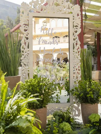 A shot focusing on the elegant and personalized decor of the wedding carnival, with a beautifully framed mirror reflecting the venue.