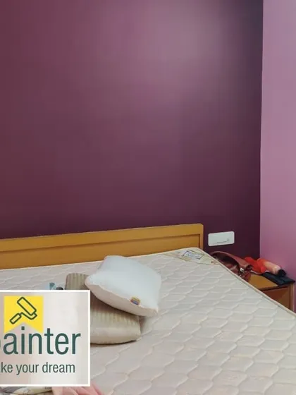 A bedroom with two-tone purple walls, using a darker shade for the main accent wall and a lighter lavender for the adjacent wall.