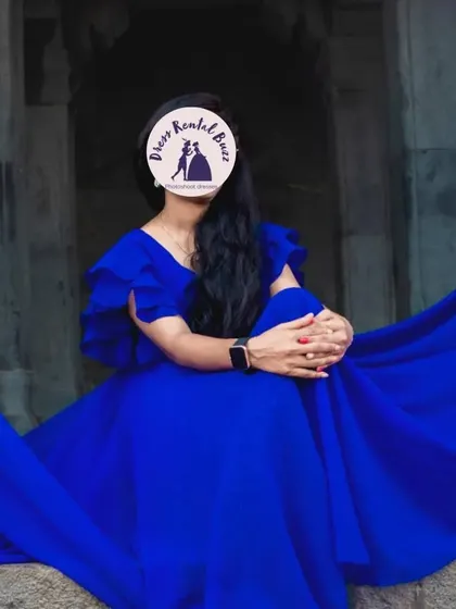 A client wearing our royal blue flying dress, seated for a portrait that showcases the dress's rich color and flowing fabric.
