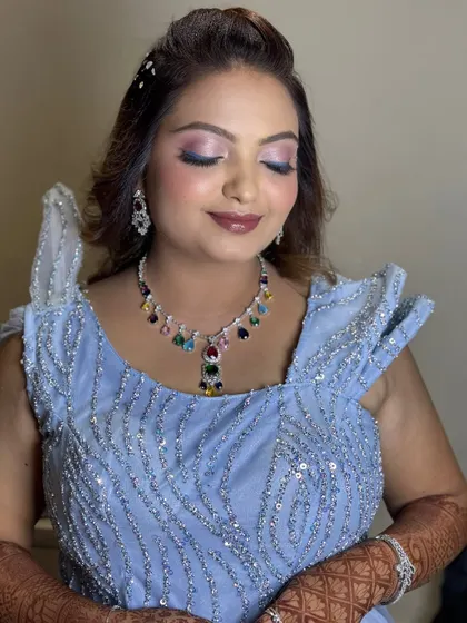 A modern reception look in a powder blue gown with a colorful statement necklace.