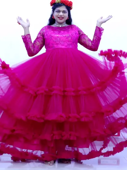 A dynamic shot of a pink ruffled maternity gown, with the layers of the skirt creating a beautiful swirling effect.