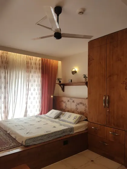 A wider view of the master bedroom, showing the platform bed that extends to create a reading zone by the window, offering a beautiful view of the lake.