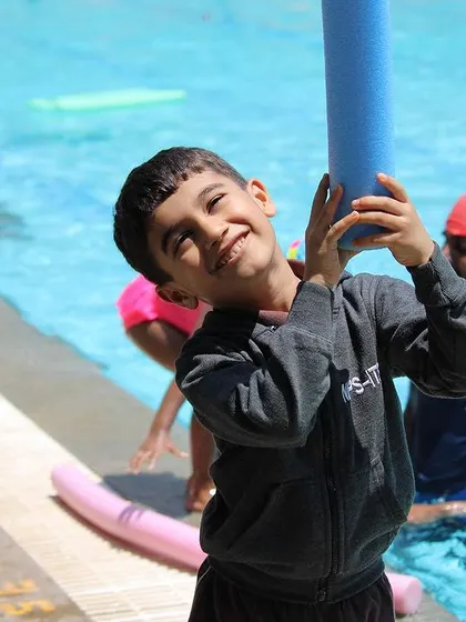 It's not all serious training. We make sure there's plenty of time for fun and games with pool equipment, like this happy swimmer enjoying his noodle.