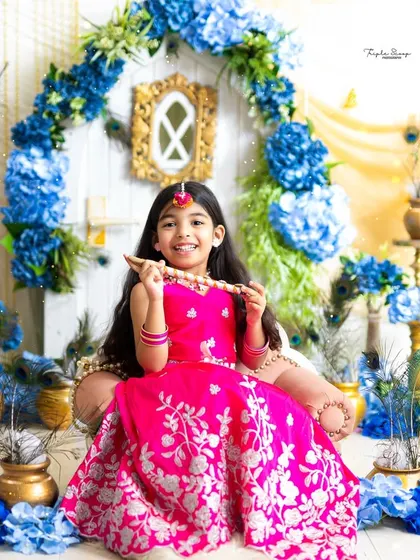 A beautiful little Radha holding a flute, with a radiant smile. I provide a complete wardrobe with traditional outfits and jewelry for these special shoots.