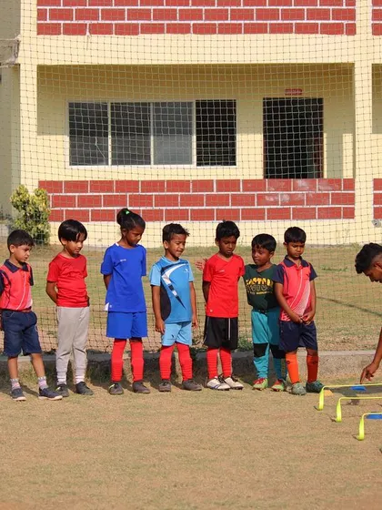 Our coach sets up the mini hurdles, preparing the youngest players for an important agility and coordination exercise.