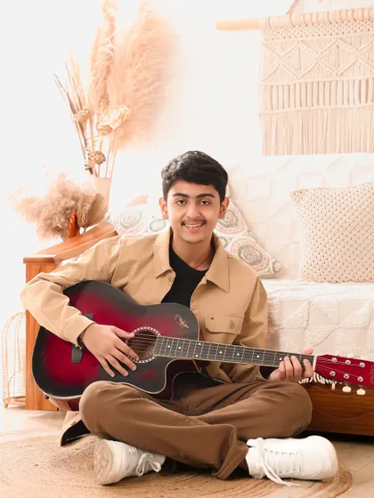 Strumming a quiet tune. This portrait, with its warm, earthy tones, captures a calm and thoughtful moment with a young guitarist.