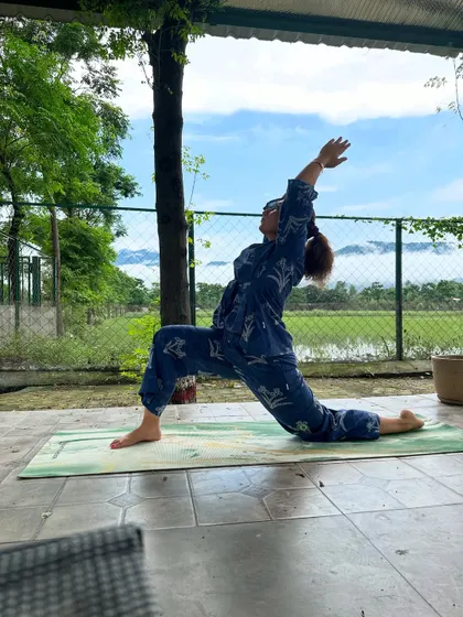 Practicing Anjaneyasana, or low lunge, to open the hips and chest. The fresh mountain air makes every breath feel more nourishing.