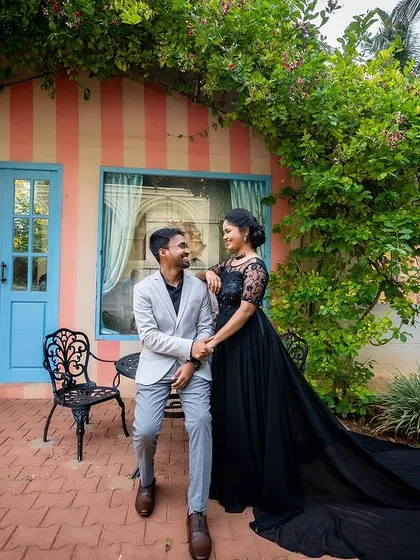 A romantic walking shot of the couple in front of a picturesque, colorful building, with the flowing dress adding movement.