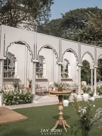 Another perspective of the expansive ivory-themed lounge, showing the thoughtful distribution of seating areas across the lawn to create multiple zones for conversation.