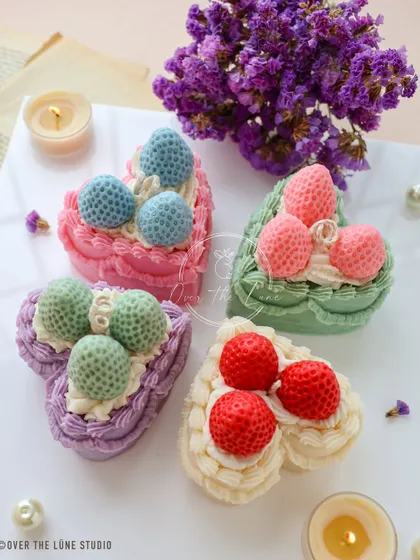 Four of my heart-shaped dessert candles, each with different colored "frosting" and strawberry toppings. They look good enough to eat, but they are even better as a decorative treat.