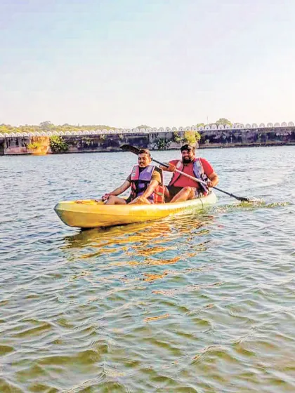 Our lakeside camps include plenty of daytime activities. Here, two guests enjoy a kayaking session on the calm water, a perfect way to explore the surroundings and have some fun before the evening party begins.