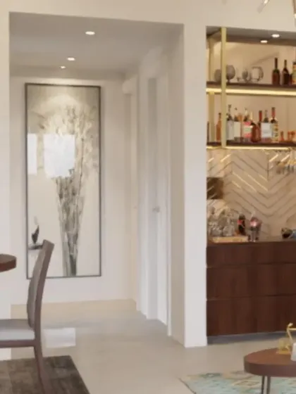 This compact home bar is cleverly integrated into the living area. It features a herringbone backsplash, rich wood cabinetry, and open shelving with gold accents, proving that you don't need a large space to have a stylish bar.