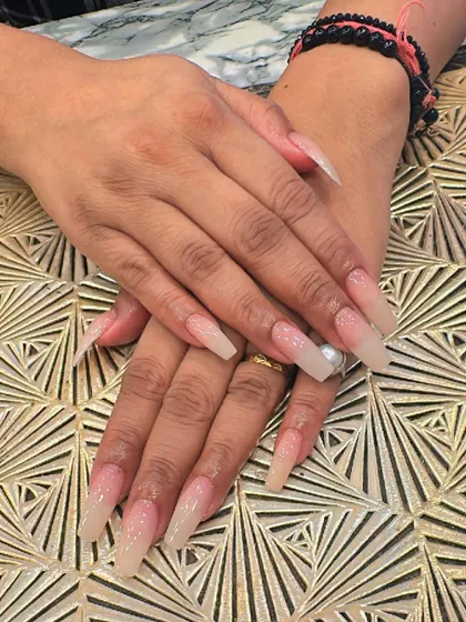 Extra-long, clear coffin nails with a very subtle nude ombre effect. This minimalist design is perfect for a clean and sophisticated look.