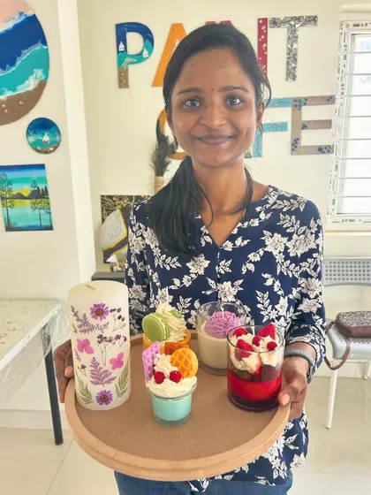 This guest is holding a tray with her beautiful creations, including a pressed flower pillar candle and dessert candles.