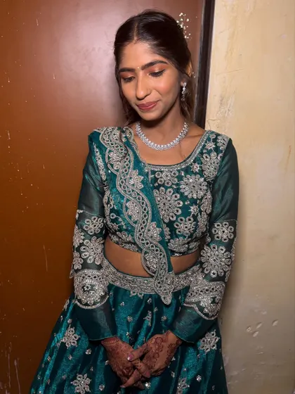 A lovely candid shot of the bridesmaid in her teal lehenga. The makeup is subtle and enhances her natural beauty.