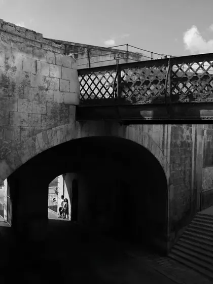 A striking black and white architectural shot from Malta, with the couple framed in the distance, creating a sense of scale and artistry.