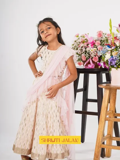 This little girl looks like a princess in my cream and gold printed lehenga with a pre-draped pink ruffled dupatta. It’s an elegant and comfortable choice for any wedding or festive event.