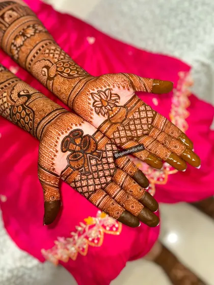 A close-up of the palms, highlighting the intricate details of the kalash and lotus motifs.