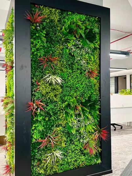 A close-up of the artificial vertical garden, showing the variety of textures and colors used to mimic a natural wall. These installations are completely maintenance-free, making them ideal for busy corporate settings.