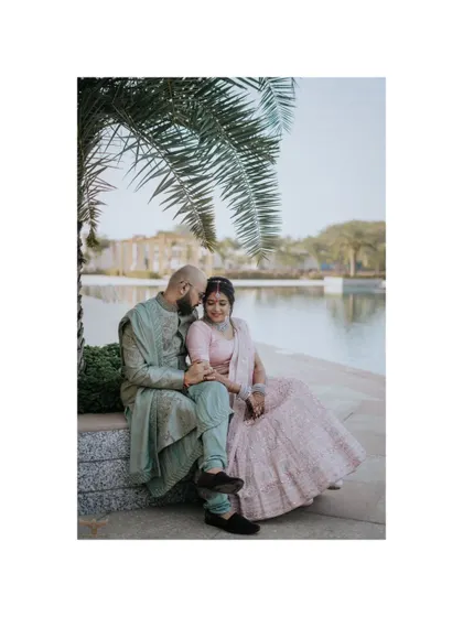 A peaceful portrait of a couple sitting by the water's edge. The serene setting and their relaxed posture create a feeling of calm and contentment, perfect for a tranquil pre-wedding session.