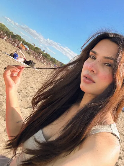 A close-up beach selfie, playing with my hair in the summer sun.