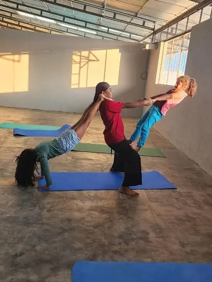 This dynamic three-person pose combines a bridge with two leaning balances, creating a visually interesting shape that challenges the whole group.