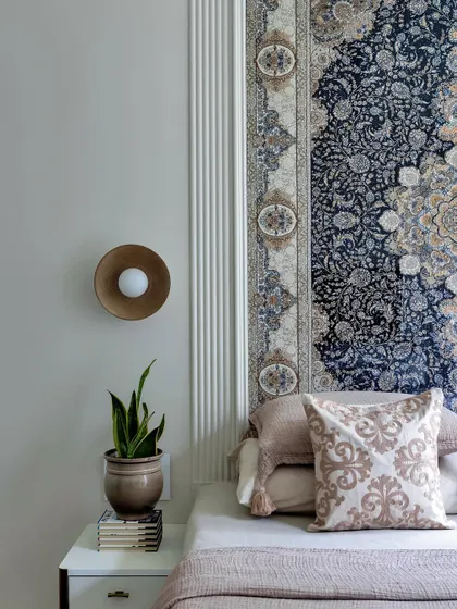 This bedroom is a perfect blend of functionality and luxury. The intricate tapestry headboard, modern brass wall sconce, and fluted wall panels create a space that feels both serene and sophisticated.