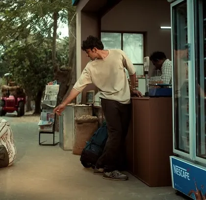 Another shot from the Nescafé road trip commercial, showing the characters at a roadside stall. The entire scene is styled to feel spontaneous and real.