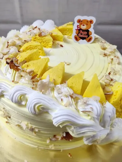 A butterscotch cake with a crunchy texture. This cake is decorated with butterscotch chips and sliced almonds.