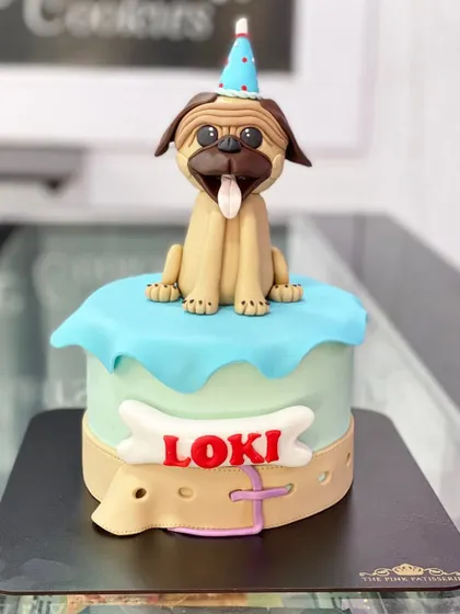A cake for a furry friend! We created this adorable pug cake for a dog's birthday, complete with a party hat and an edible collar.