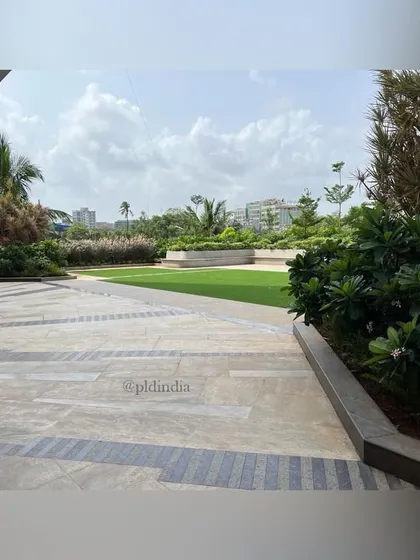 A patterned stone walkway cuts across the corporate plaza, leading towards the central lawn. I use contrasting stone patterns to define pathways and add geometric interest to large paved areas, guiding movement through the landscape.