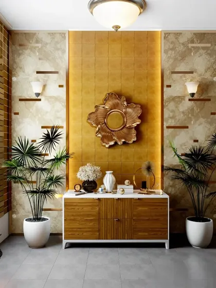 A glamorous and opulent foyer design with gold-textured walls and a large floral mirror. The wood and white console is flanked by tall plants, creating a luxurious and vibrant entrance.