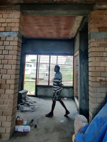 A view of the construction site, showing the exposed brick walls and filler slab roof.