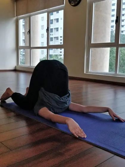 Every pose tells a story of growth. This student explores Karnapidasana (Ear Pressure Pose), a deep stretch for the entire back body.