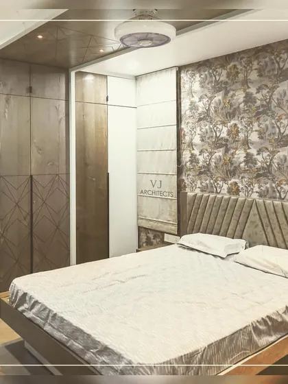 This angle of the bedroom with floral wallpaper shows the custom wardrobe and a cozy window seat, making the most of the available space.
