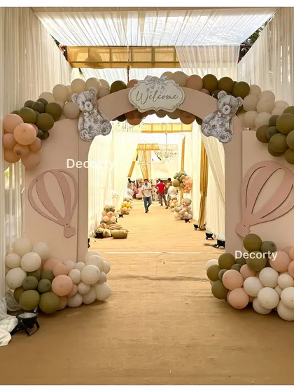 The elegant entrance arch for a teddy bear-themed welcome party, inviting guests into a beautifully styled tented space.