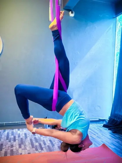 This is an advanced aerial yoga pose that combines an inversion with a deep backbend. The hammock is wrapped around my body to provide the necessary support to hold this challenging and beautiful shape.