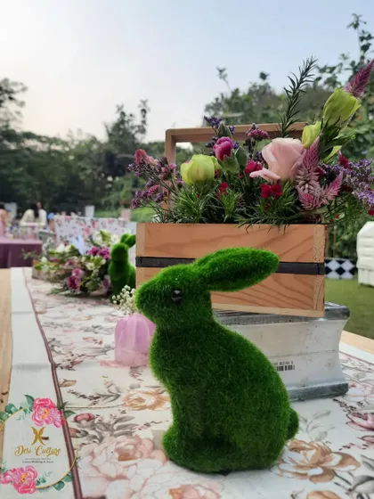 A mossy green rabbit prop sits on a table runner, part of the detailed centerpieces that brought the Wonderland theme to life.