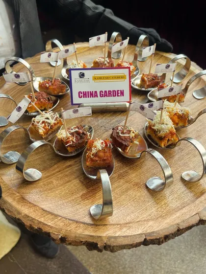 Elevating starter presentation with our "China Garden" appetizers served on unique spoon-handled platters. Each bite-sized portion is carefully crafted to be a visual and flavorful delight.