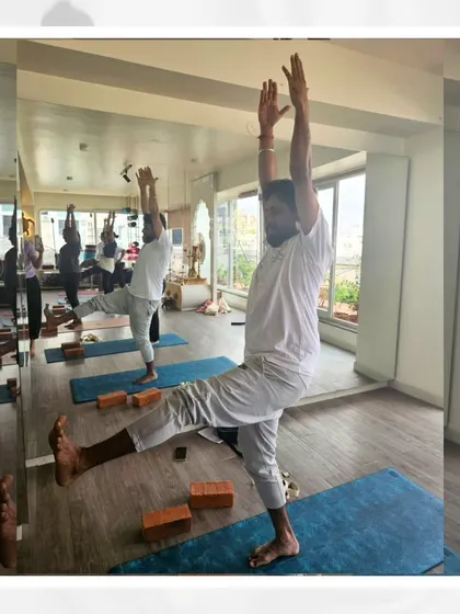 A group of students practices Utthita Hasta Padangusthasana, showcasing the collective focus on balance and stability within our community.